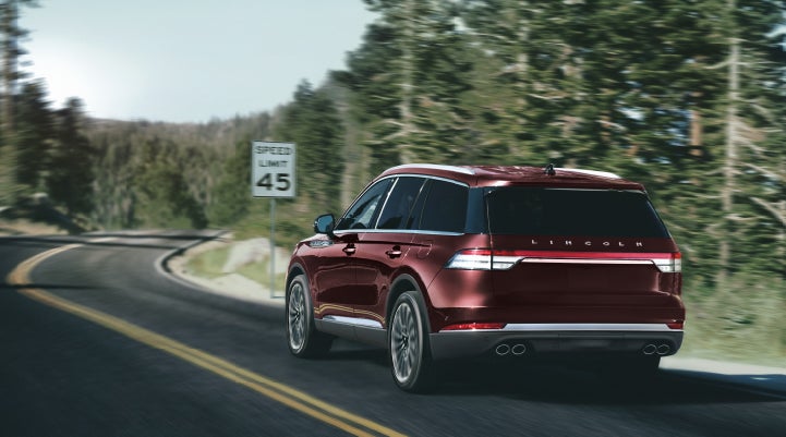 A 2024 Lincoln Aviator® SUV is being driven on a winding mountain road | White's Canyon Motors - Lincoln in Spearfish SD
