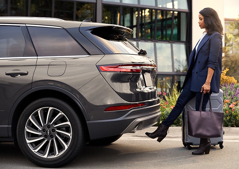 A woman with her hands full uses her foot to activate the available hands-free liftgate. | White's Canyon Motors - Lincoln in Spearfish SD